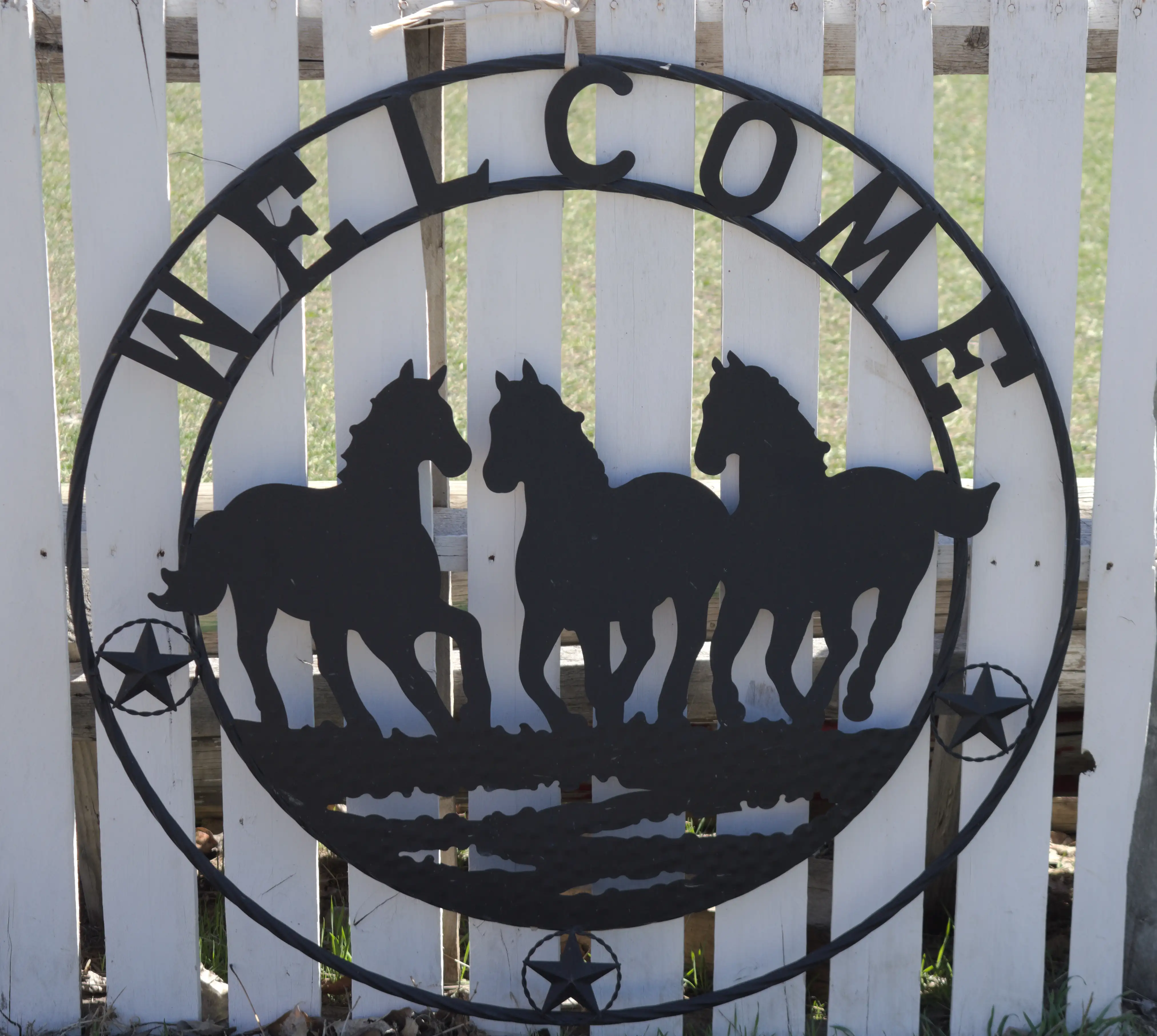 The hand-painted Welcome sign on the fence at Gentle Giant Acres